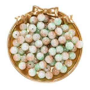 Detail of 10mm ice-cracked glass beads with green and brown tones in a gold tray