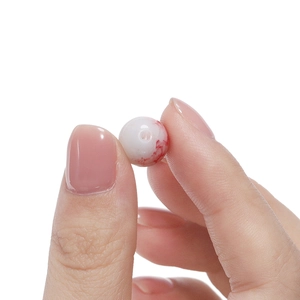 Détail d'une perle en verre de 10mm motif œil avec veines rouges pour bijoux DIY
