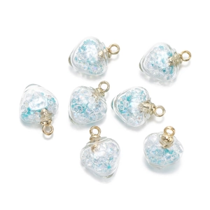Détail de breloques cœur en verre avec paillettes bleues pour création de bijoux DIY