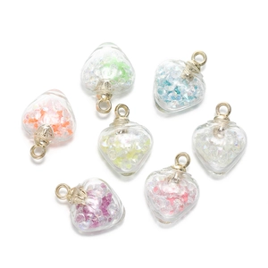 Détail de pendentifs cœur en verre coloré avec anneaux dorés pour la création de bijoux DIY