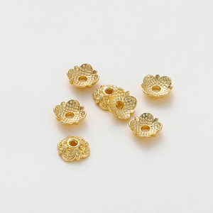 Macro detail of 18k gold plated flower bead caps with embossed vintage texture for DIY jewelry