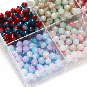 Macro detail of 10mm colorful ice cracked glass beads in a clear organizer box