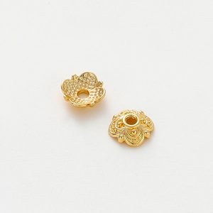 Macro shot of 18k gold plated flower bead caps with detailed filigree for DIY jewelry