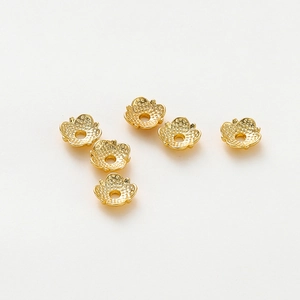 Detail of 18k gold-plated flower bead caps with hollow petal texture for DIY jewelry