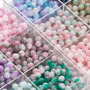 Macro shot of colorful 10mm cracked glass beads stored in a clear acrylic grid box