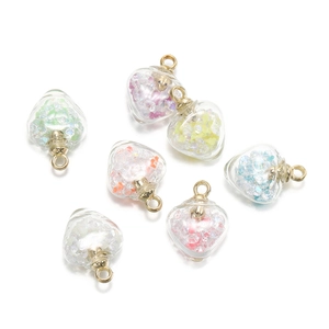 Détail macro de pendentifs en verre en forme de cœur avec paillettes et anneaux d'or
