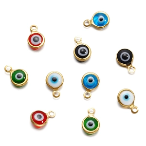 Macro view of colorful enamel evil eye connectors with gold metal frames for DIY jewelry making