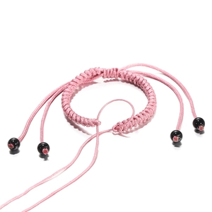 Detail van roze handgevlochten spiraalvormige armband met zwarte obsidiaan kraalaccenten