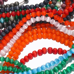 Detailed view of colorful 2mm faux cat-eye glass beads showing silky luster and vibrant hues