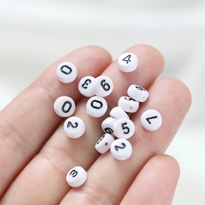 Acrylic white number beads with black print for DIY jewelry making on palm display