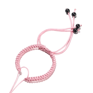 Detailweergave van het roze handgeweven armbandkoord met verstelbare sluiting en kralen