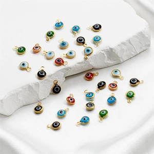 Macro shot of colorful evil eye connectors for jewelry making on elegant silk fabric