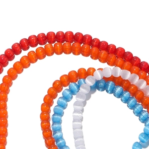 Macro shot of 2mm cat-eye effect glass beads in red, orange, blue, and white colors