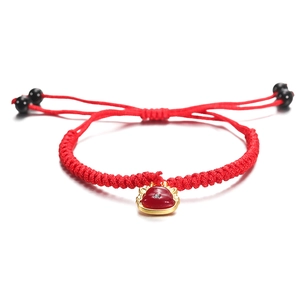 Detail van rood handgeweven geluksarmband met verstelbare goudkleurige hanger aan koord