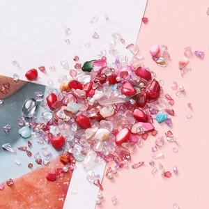 Detailopname van kleurrijke onregelmatige glasstukjes en schelpen voor DIY-nagelkunst
