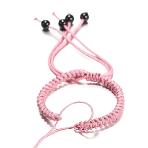 Detail van de roze handgeweven armband met spiraalvlechtpatroon en verstelbare zwarte kralen