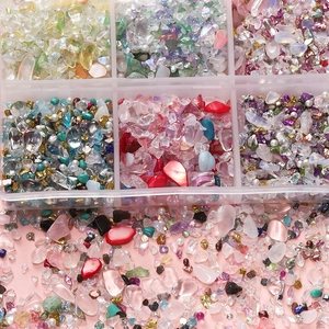 Gedetailleerde weergave van gemengde gekleurde glasstenen en schelpfragmenten in DIY-doos