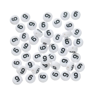 Close-up of white acrylic round flat beads with black number nine for DIY jewelry making