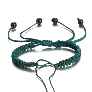 Detail van een handgeweven donkergroene armband met verstelbare schuifknoop en kralen