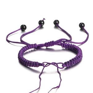 Verstelbare paarse gevlochten nylon armband met gepolijste zwarte kralen op een witte basis