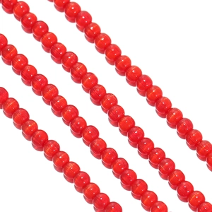 Macro shot of 2mm vibrant red cat-eye glass beads for DIY jewelry making and beadwork