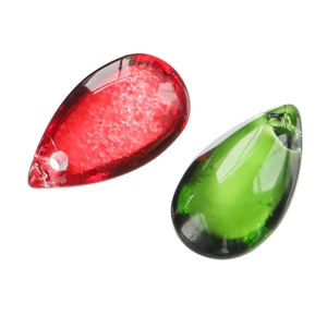 Macro detail of red and green glass teardrop beads with holes for DIY jewelry making