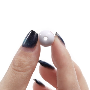 Close-up showing the center hole of a white acrylic billiard bead for DIY jewelry making.