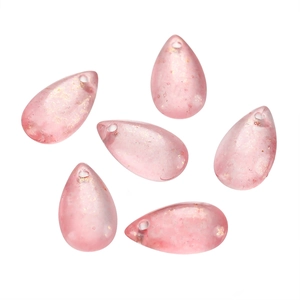 Macro shot of 8x14mm pink waterdrop glass beads with sparkling gold glitter for DIY crafts