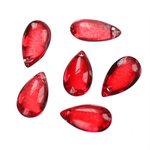 Macro detail of six red teardrop glass beads with drill holes for DIY jewelry making