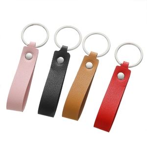 Close-up of four-color leather keychains with lychee texture and silver metal rings