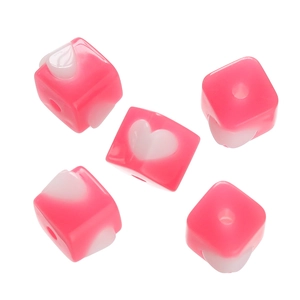 Makro-Detail von 5 rosa quadratischen Acrylperlen mit weißen Herzmustern für DIY-Basteln