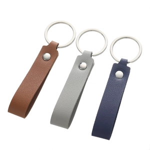 Macro view of textured faux leather keychains in brown, light grey and dark blue colors