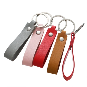 Detail view of colorful lychee grain leather keychains with silver metal rivets and rings