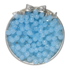 Macro shot of 8x7mm light blue glass beads with a polished finish in a silver tray