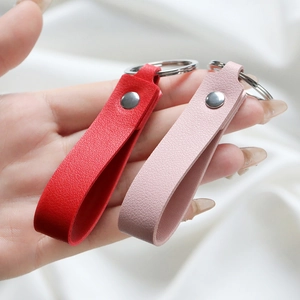 Close-up of red and pink pebble grain faux leather keychains with silver metal ring
