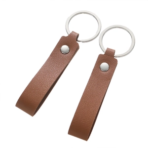 Close-up of brown pebbled leather keychains with silver metal rivets and rings