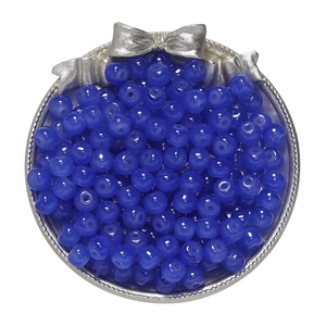 Detailed view of dark blue apple-shaped glass beads in a decorative silver tray for DIY