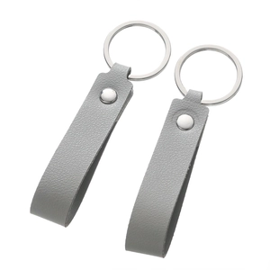 Detail view of grey lychee texture leather keychain with silver metal ring and rivet