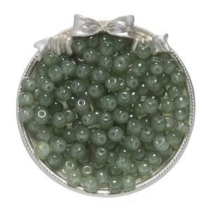 Macro view of dark green apple-shaped glass beads for DIY jewelry making and crafts