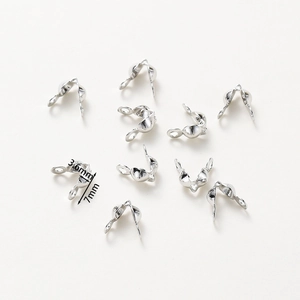 Macro view of 7x3.6mm silver plated jewelry fold-over calottes and connector clasps