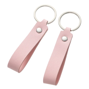 Detail of pink faux leather keychains with lychee texture and silver metal rings