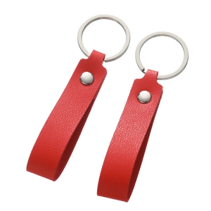 Macro detail of red faux leather keychain loops with silver rivets and metal rings
