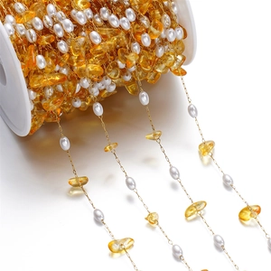 DIY jewelry chain with white pearls and yellow stones on a spool for necklace making