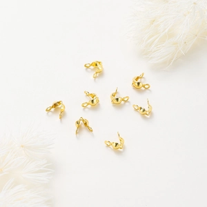 Macro view of gold-plated bead tips with double loops for DIY jewelry connecting