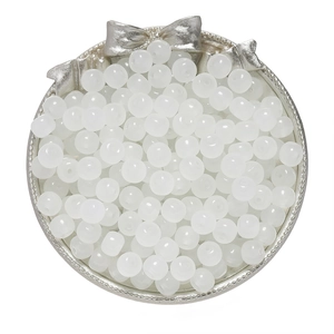 Macro shot of 8x7mm translucent white apple-shaped glass beads in a silver tray for DIY jewelry