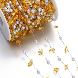 Detail of DIY stainless steel chain with white pearls and yellow irregular gravel stones