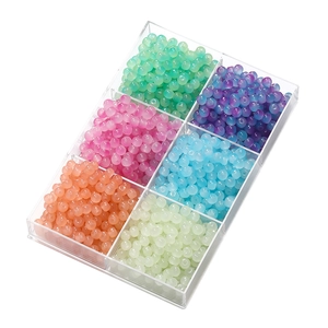 Detail of 6-grid box filled with colorful translucent apple-shaped beads for DIY jewelry
