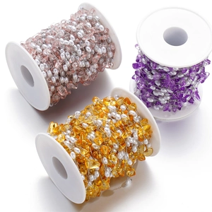 Detail of colorful irregular gravel and pearl beads wrapped on white spools for DIY jewelry