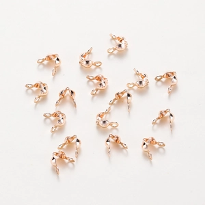 Macro shot of rose gold-plated crimp covers and bead tips for DIY jewelry making