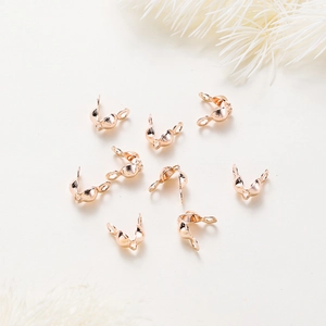 Macro shot of rose gold shell crimp bead covers with double loops for DIY jewelry making